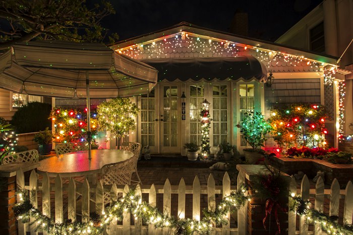 Porch and roofline strung with warm holiday lights
