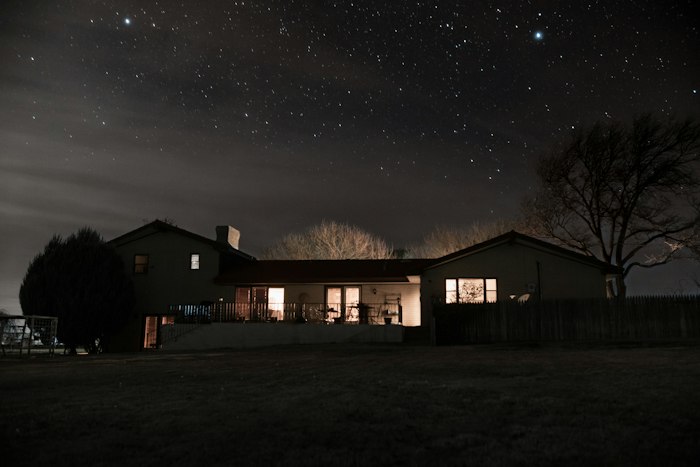 House under a night sky with exterior lighting